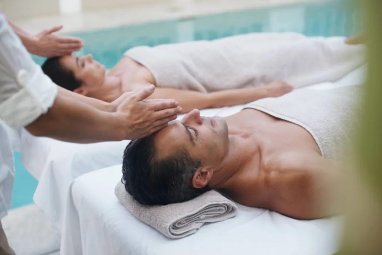 couple receiving spa treatment beside pool